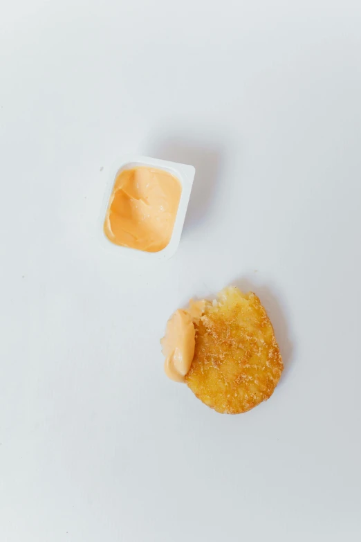 a couple of pieces of food sitting on top of a white table, reddit, visual art, condorito, mayonnaise, textured base ; product photos, battered