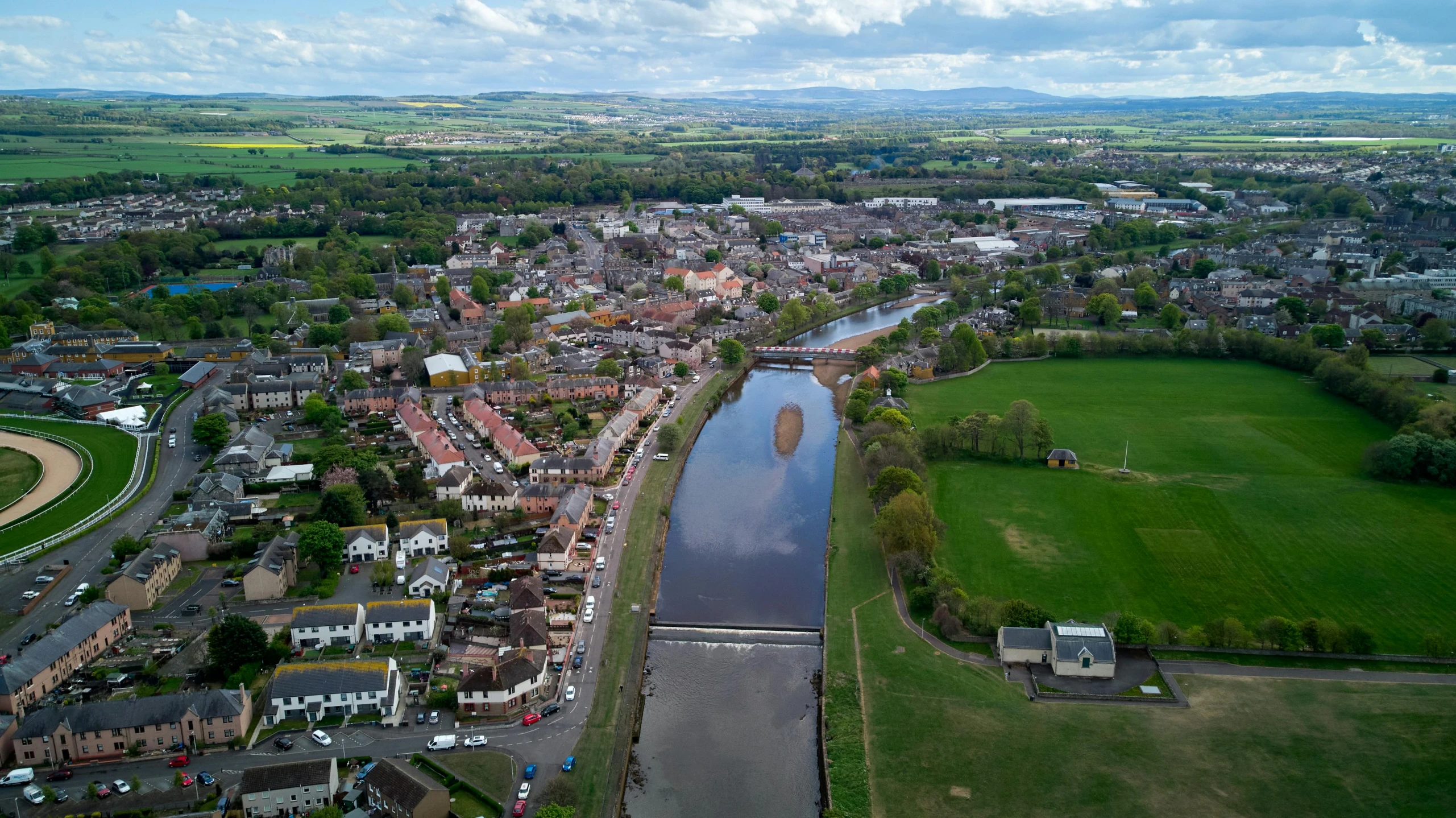 an aerial view of a town with a river running through it, by Kev Walker, pexels contest winner, happening, dunwall city, 4k footage, today\'s featured photograph 4k, balloon