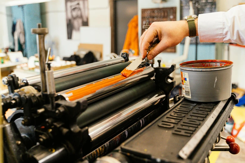 a close up of a person using a machine, a silk screen, unsplash, private press, gray and orange colours, medium format, style of shepherd fairey, hasselblad quality