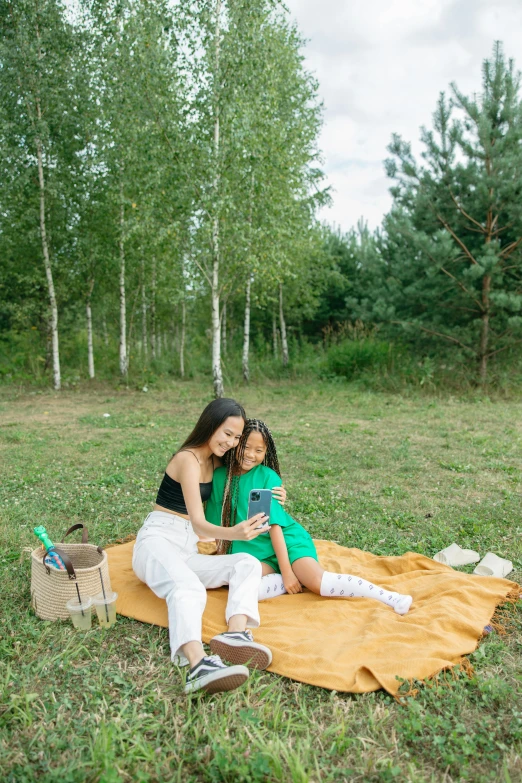 a couple of women sitting on top of a grass covered field, having a picnic, perfect android girl family, in russia, profile image