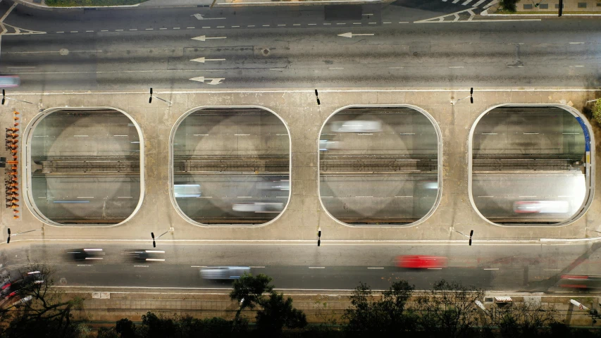 a city street filled with lots of traffic next to a tall building, inspired by Andreas Gursky, round windows, zezhou chen, national geographic photo award, aqueducts