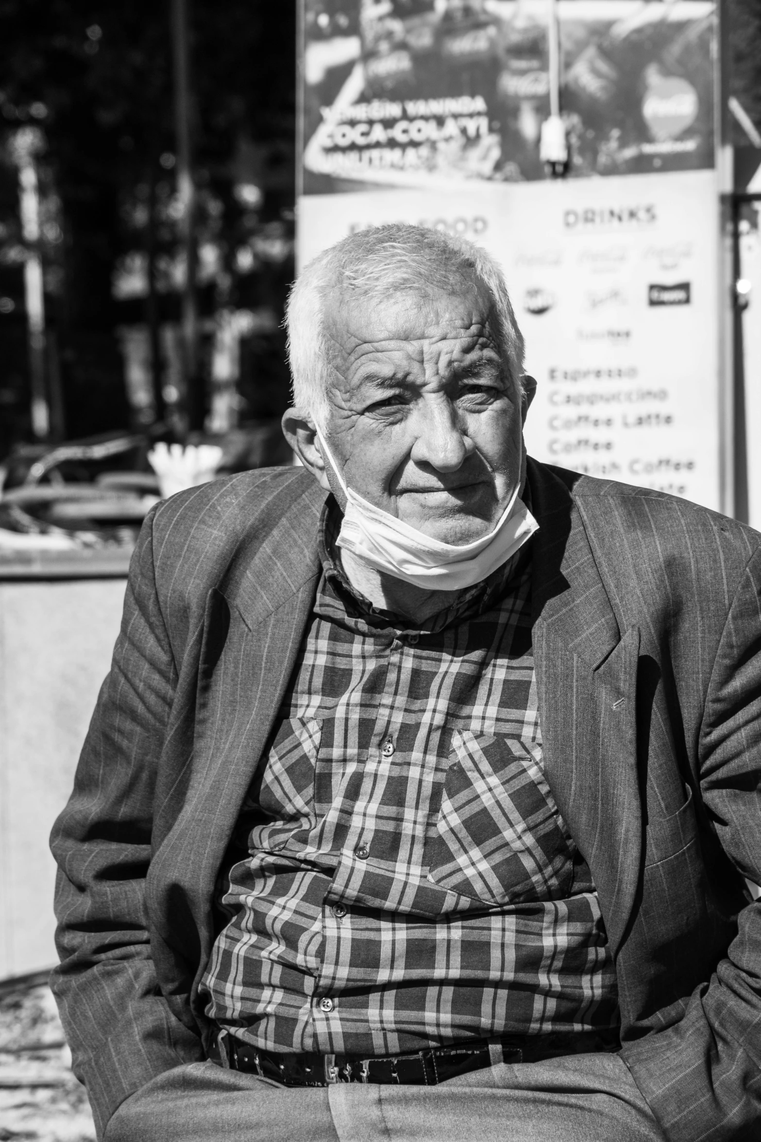 a black and white photo of a man sitting on a bench, a black and white photo, pexels contest winner, photorealism, wearing facemask, yellowed with age, mircea suciu, in town