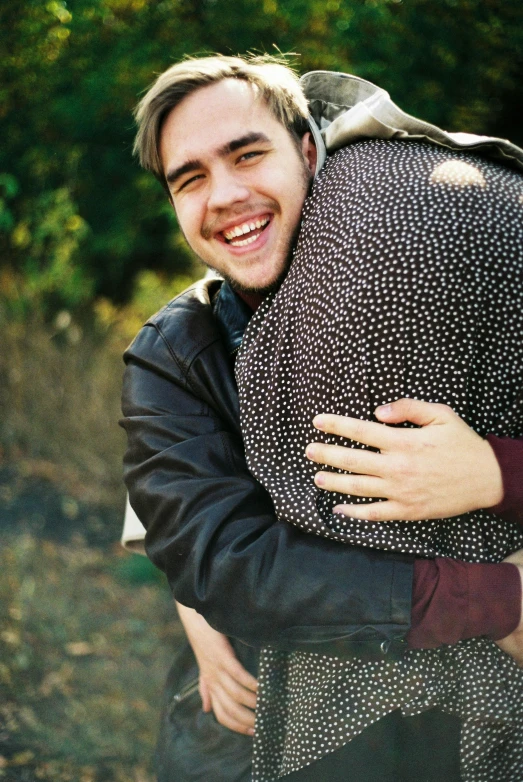 a couple of people that are hugging each other, an album cover, unsplash, carrying big sack, joe keery, vsco film grain, smiling male