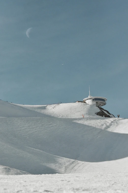 a man riding a snowboard down the side of a snow covered slope, les nabis, seen from a distance, alpine architecture, the moon on the top right, sitting on top of a cryopod