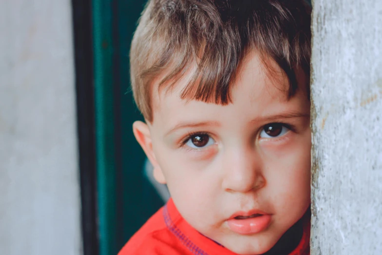 a close up of a child wearing a red shirt, a picture, pexels contest winner, sad green eyes, leaning on door, 15081959 21121991 01012000 4k, caring fatherly wide forehead