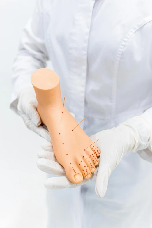 a close up of a person holding a plastic object, feet posing, medical depiction, dotting, displayed