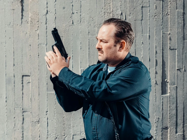 a man holding a gun in front of a wall, unsplash, realism, police officer hit, andy richter, confident action pose, profile image
