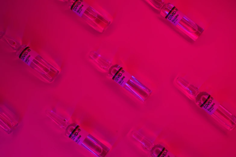 a group of vials sitting on top of a pink surface, inspired by Herbert Bayer, visual art, vodka, thumbnail, fluo details, loreal