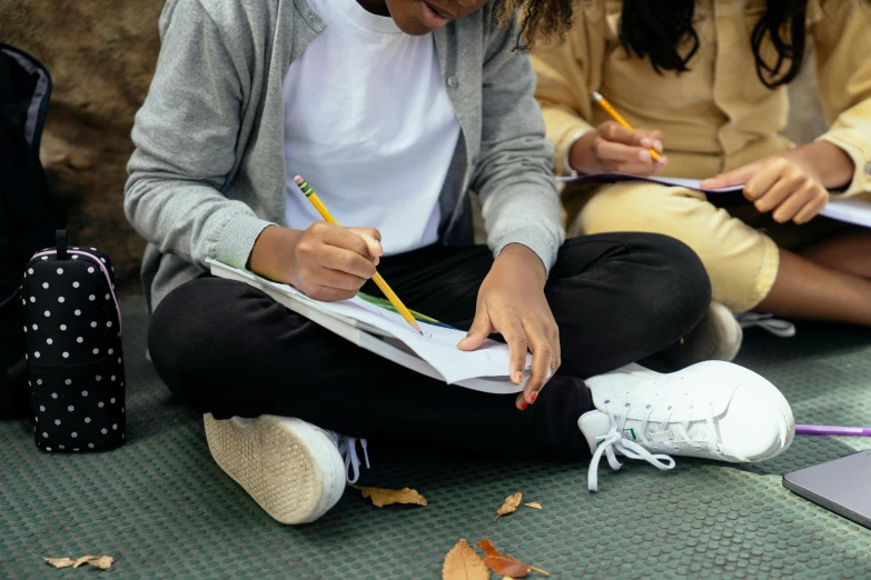 a group of girls sitting next to each other on the ground, a child's drawing, by Bertram Brooker, pexels contest winner, academic art, holding notebook, sitting on a leaf, detailed shot legs-up, writing on a clipboard