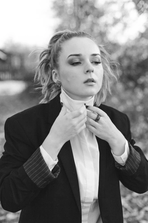 a black and white photo of a woman adjusting her tie, a black and white photo, inspired by Claire Dalby, tumblr, florence pugh, android 18, sophia lillis, ((portrait))