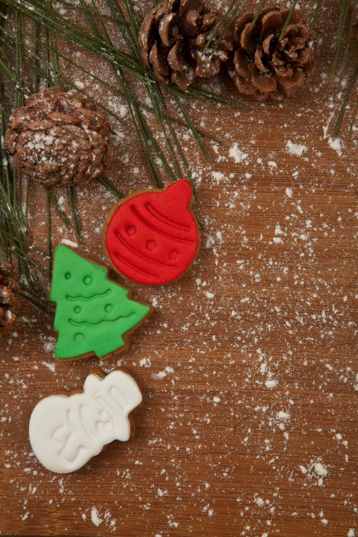a wooden table topped with christmas decorations and pine cones, pexels, folk art, baking cookies, thumbnail, back, multi chromatic