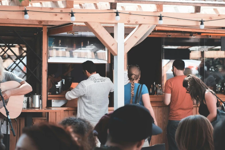 a group of people standing in front of a bar, by Niko Henrichon, pexels, renaissance, food stalls, background image, warm weather