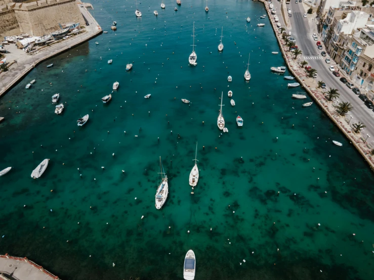 a group of boats floating on top of a body of water, by Tom Wänerstrand, pexels contest winner, harbour, teal aesthetic, wide high angle view, thumbnail