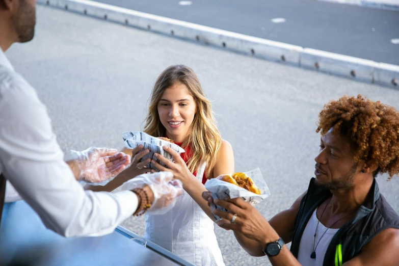 a man handing food to a woman on the side of the road, nina agdal, vanessa morgan, rj palmer, profile image