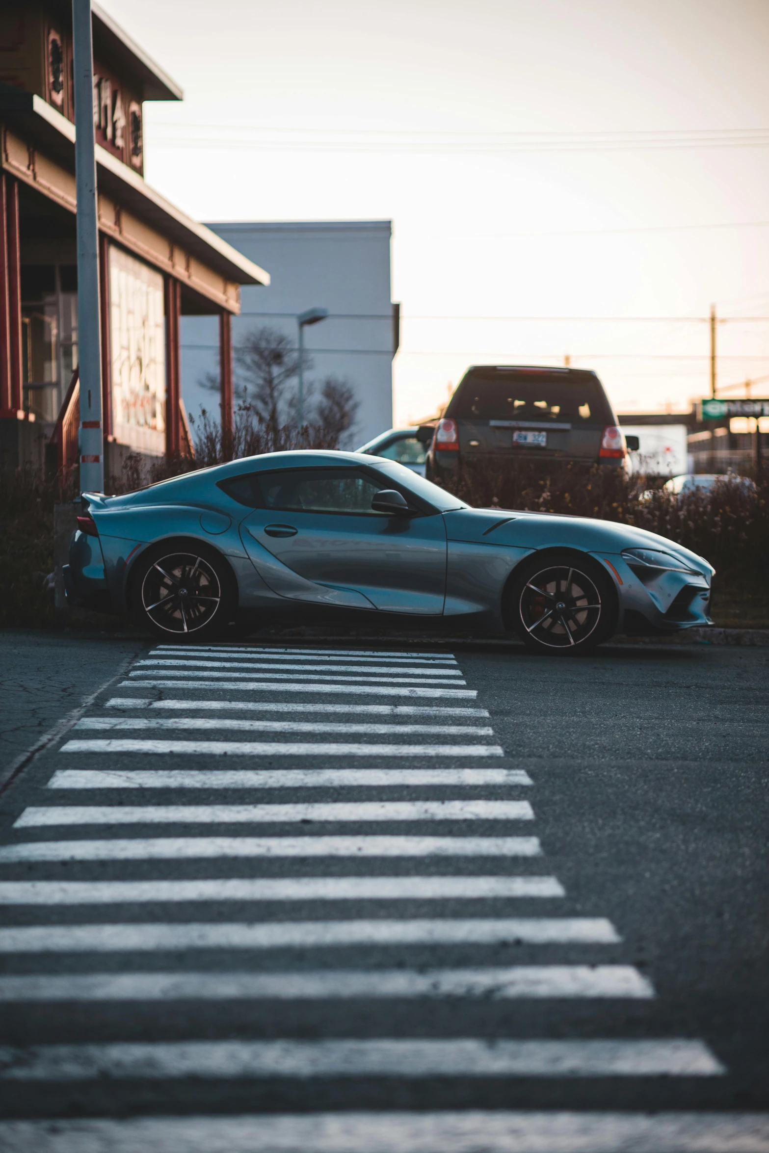 a blue sports car parked on the side of the road, pexels contest winner, hyperrealism, toyota supra, intersection, casually dressed, blue and gray colors