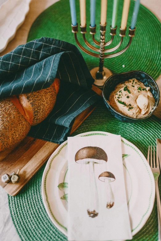 a close up of a plate of food on a table, inspired by Elsa Beskow, unsplash, cozy calm! fabrics textiles, deep green, made of mushrooms, bread