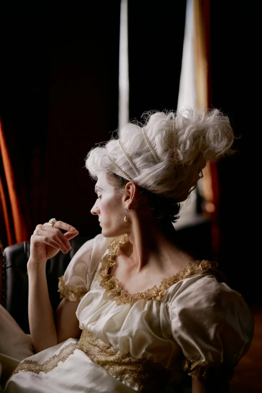 a woman sitting in a chair looking out a window, a portrait, inspired by Jean-Marc Nattier, unsplash, rococo, elaborate hair worn up, tilda swinton, ( ( theatrical ) ), slide show