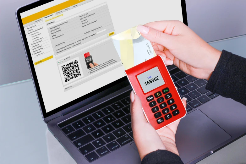 a person holding a calculator in front of a laptop, a digital rendering, by Matthias Stom, yellow and red color scheme, barcode, cyberdeck computer terminal, official product image