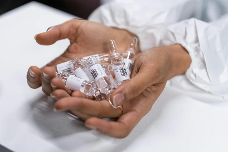 a person holding a bunch of pills in their hands, unsplash, process art, glass vials, government archive photograph, made of lab tissue, thumbnail