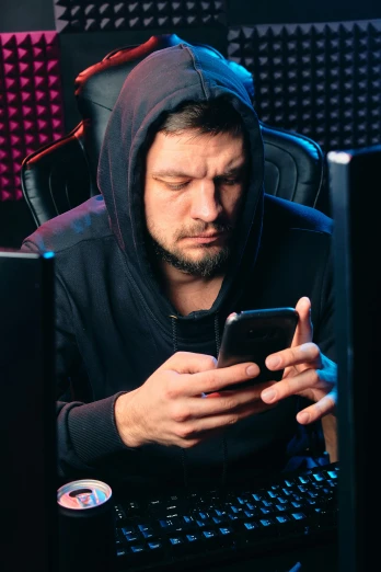 a man in a hoodie looking at a cell phone, gaming room, discord profile picture, pouting, e-sport style