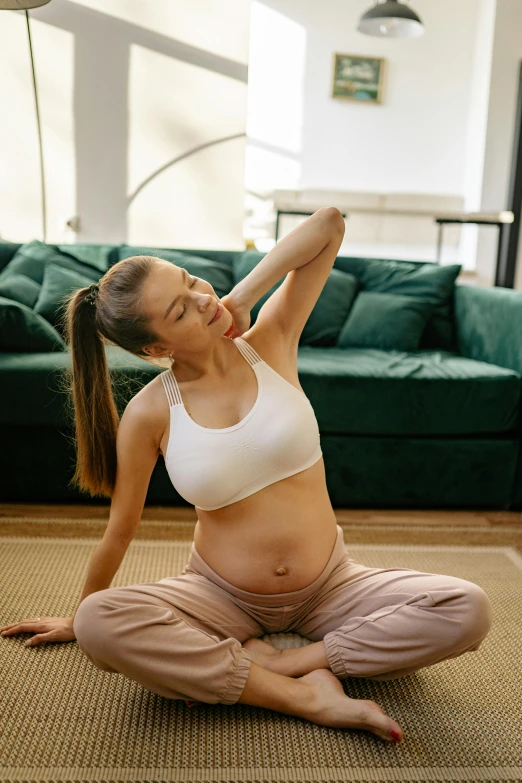 a pregnant woman doing yoga in a living room, shutterstock, figuration libre, her belly button is exposed, sitting dynamic pose, australian, photograph taken in 2 0 2 0