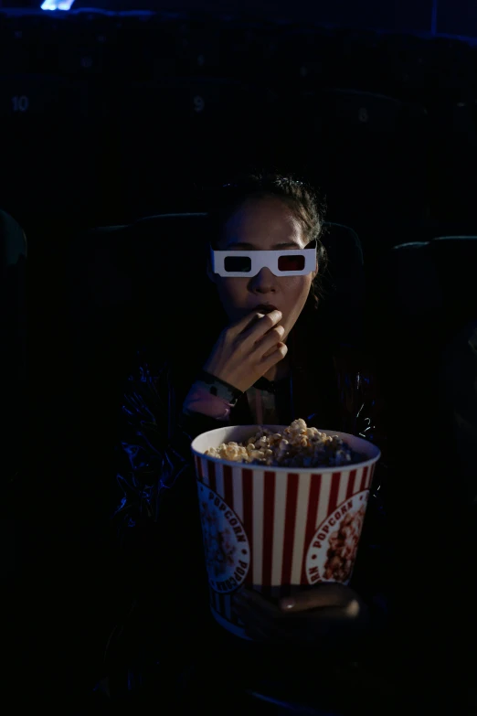 a woman eating popcorn while wearing 3d glasses, a hologram, pexels, video art, nighttime scene, [ theatrical ], imdb, ( ( theatrical ) )