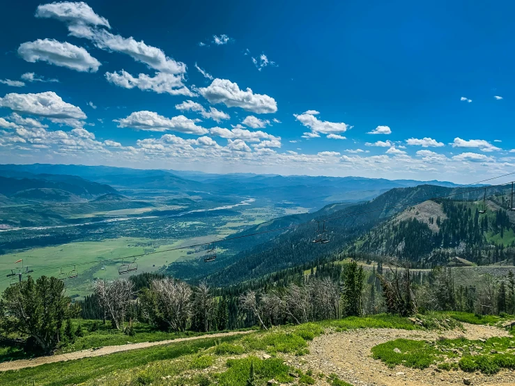 a view of the mountains from the top of a mountain, by Arnie Swekel, unsplash contest winner, idaho, bright summer day, downhill landscape, conde nast traveler photo