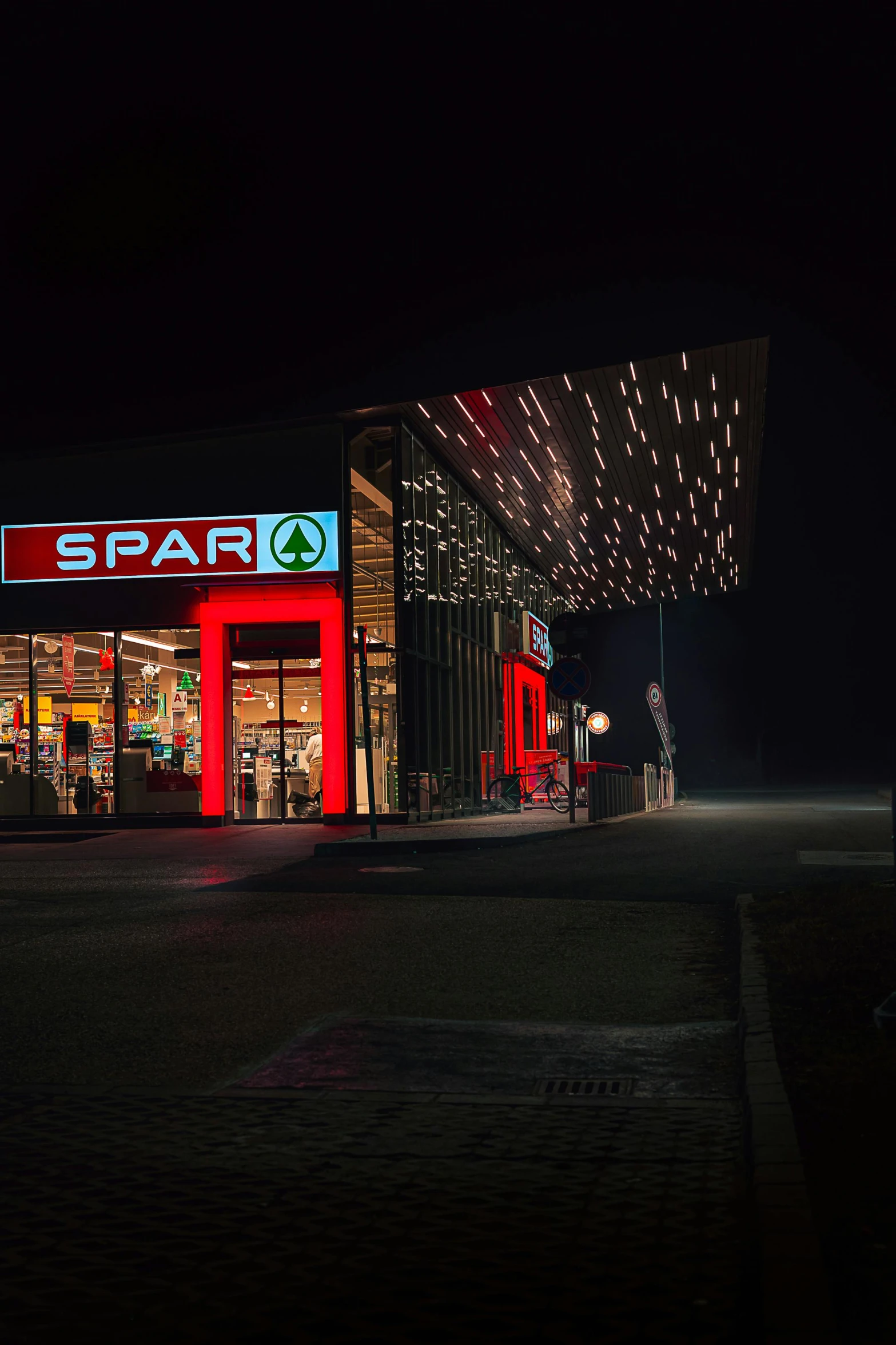 a car is parked in front of a spark gas station, by Sebastian Spreng, red led lights, spartan, : :, shop front