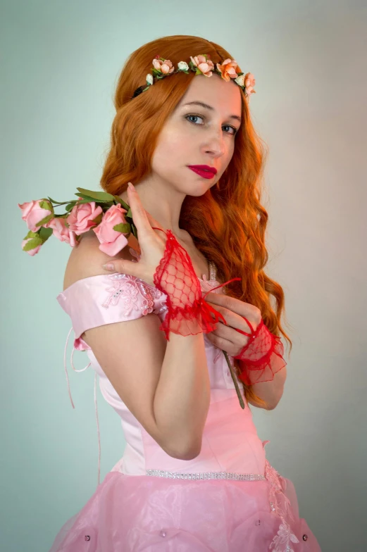 a woman in a pink dress with flowers in her hair, an album cover, inspired by Pierre Auguste Cot, renaissance, triss merigold cosplay, elbow gloves, cosplay photo, dressed in a frilly ((lace))