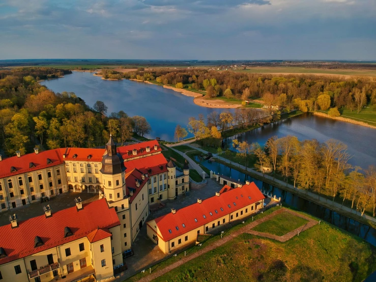 a large building next to a body of water, by Petr Brandl, pexels contest winner, in legnica, aerial view of an ancient land, thumbnail, peter the great