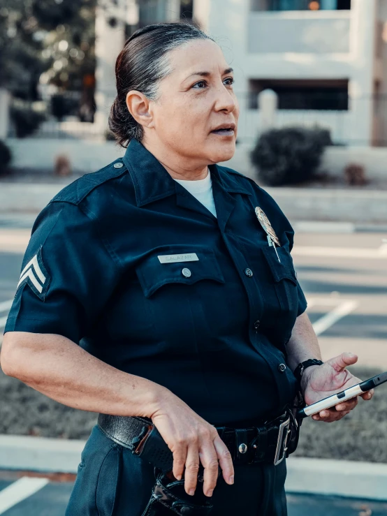 a woman in a police uniform holding a cell phone, by Alison Geissler, unsplash, portrait of danny trejo, 2019 trending photo, wearing a general\'s uniform, concerned