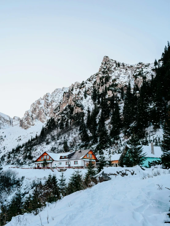 a couple of houses sitting on top of a snow covered slope, photo of džesika devic, in an epic valley, interior of a mountain hut, winter lake setting