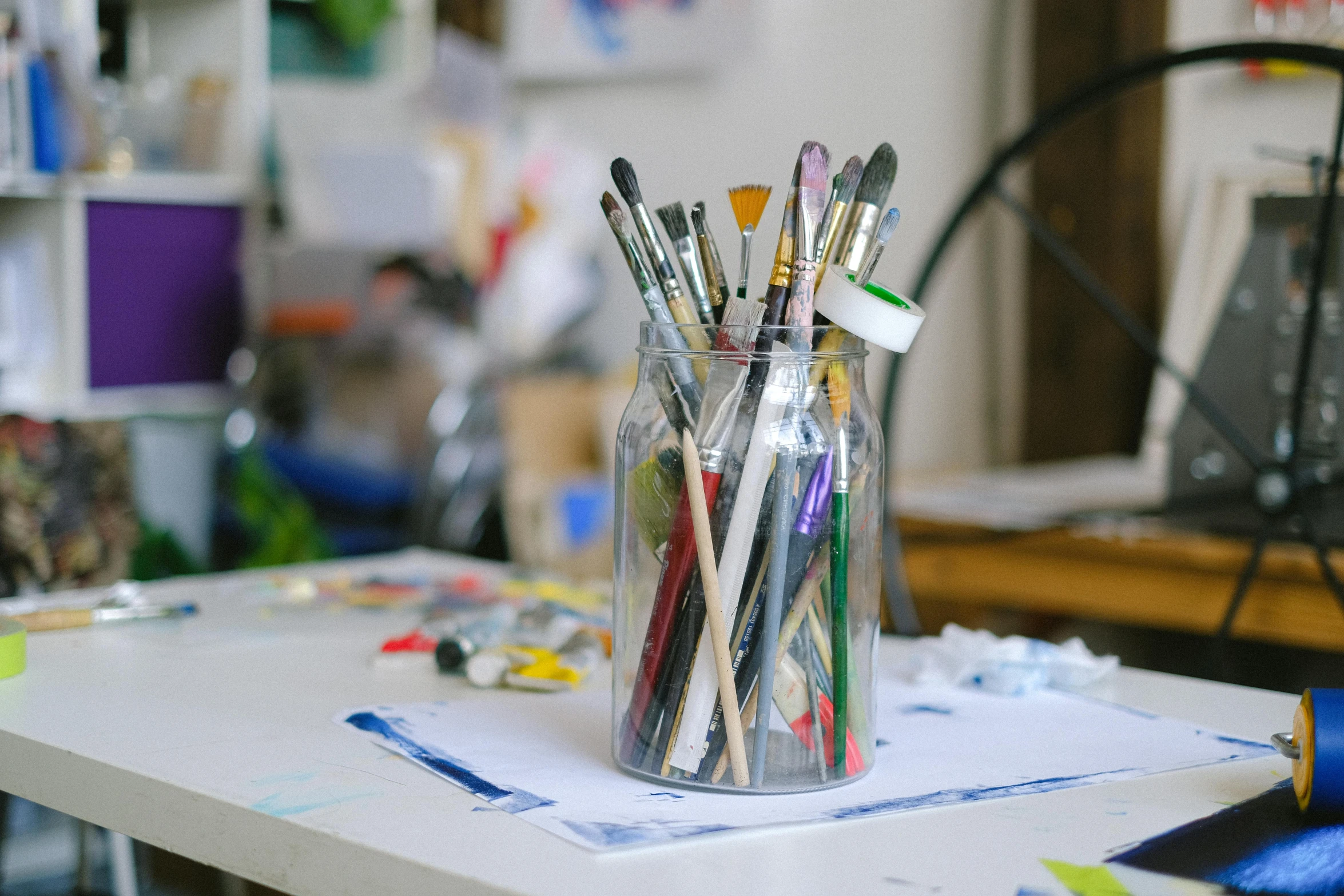 a jar filled with pens sitting on top of a table, a photorealistic painting, trending on pexels, holding paintbrushes, white wall coloured workshop, in a workshop, ilustration