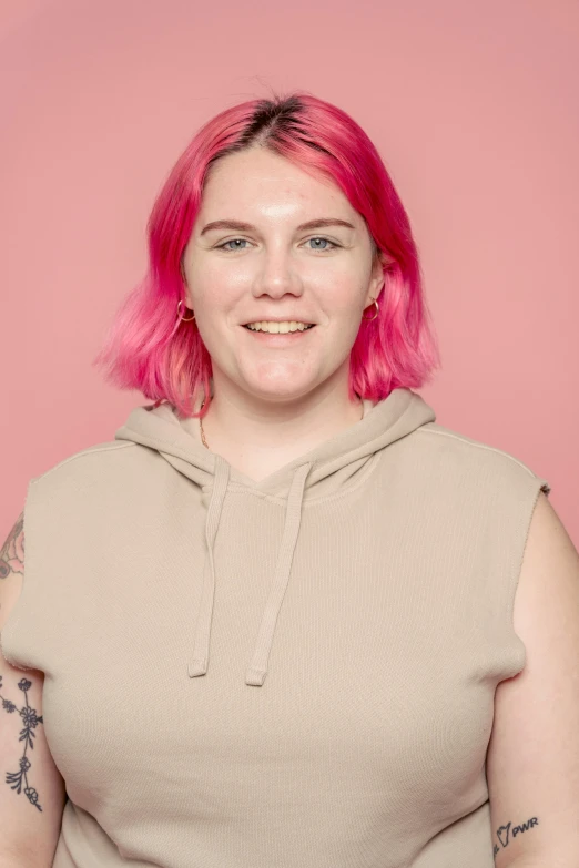 a woman with pink hair posing for a picture, matt mute colour background, slightly smiling, low quality photo, half - length photo