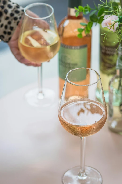 a couple of wine glasses sitting on top of a table, natural point rose', holding a drink, botanicals, zoomed in