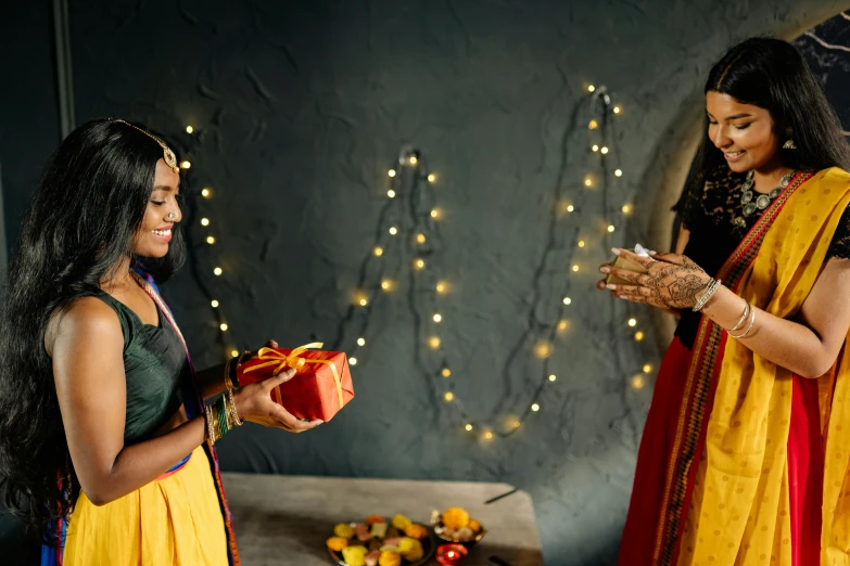 a couple of women standing next to each other, pexels contest winner, hurufiyya, giving gifts to people, intricate led jewellery, promo still, with yellow cloths