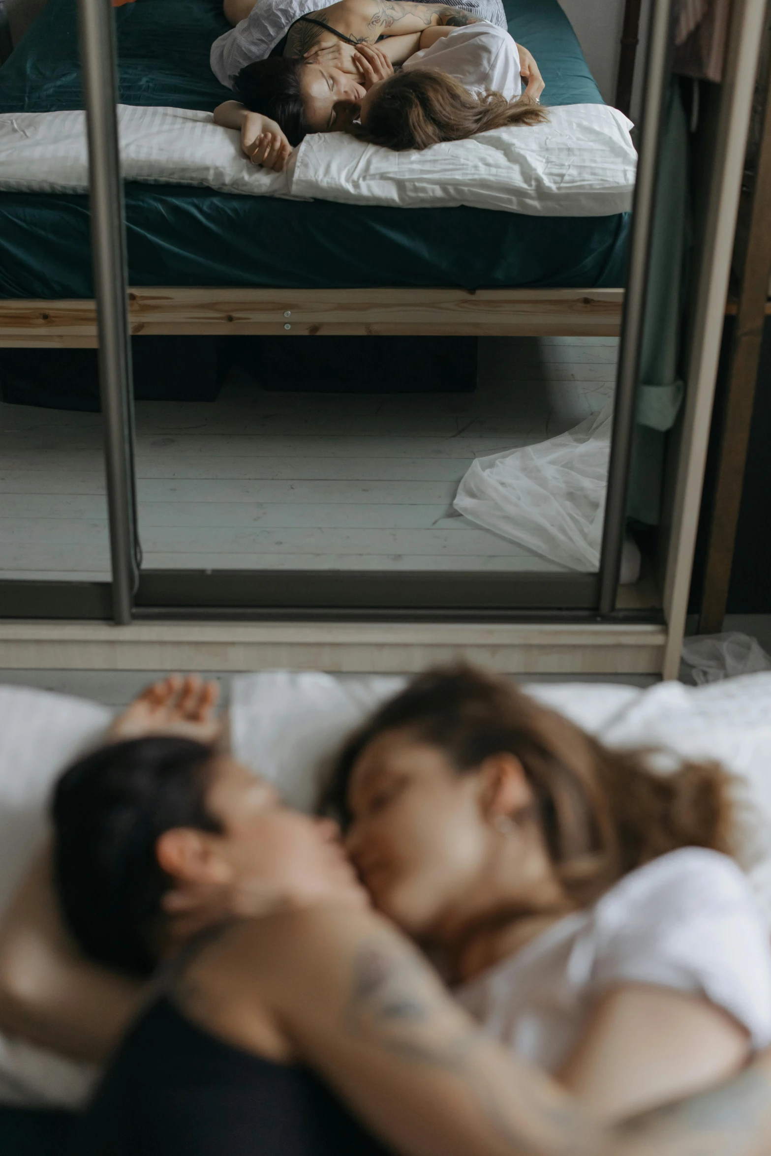 a woman laying on top of a bed next to a baby, inspired by Elsa Bleda, pexels contest winner, romanticism, lesbian kiss, gif, ignant, brunettes