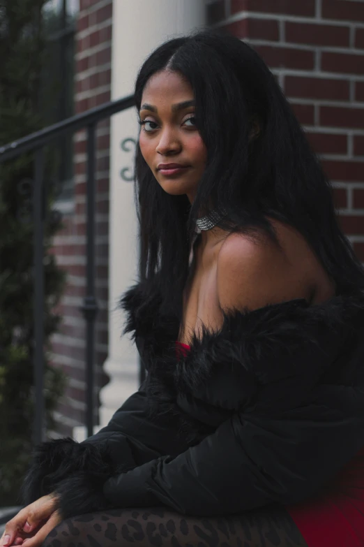 a woman sitting on the steps of a building, an album cover, by Andrew Stevovich, pexels contest winner, renaissance, black straight hair, model wears a puffer jacket, schomburg, leather fur jacket