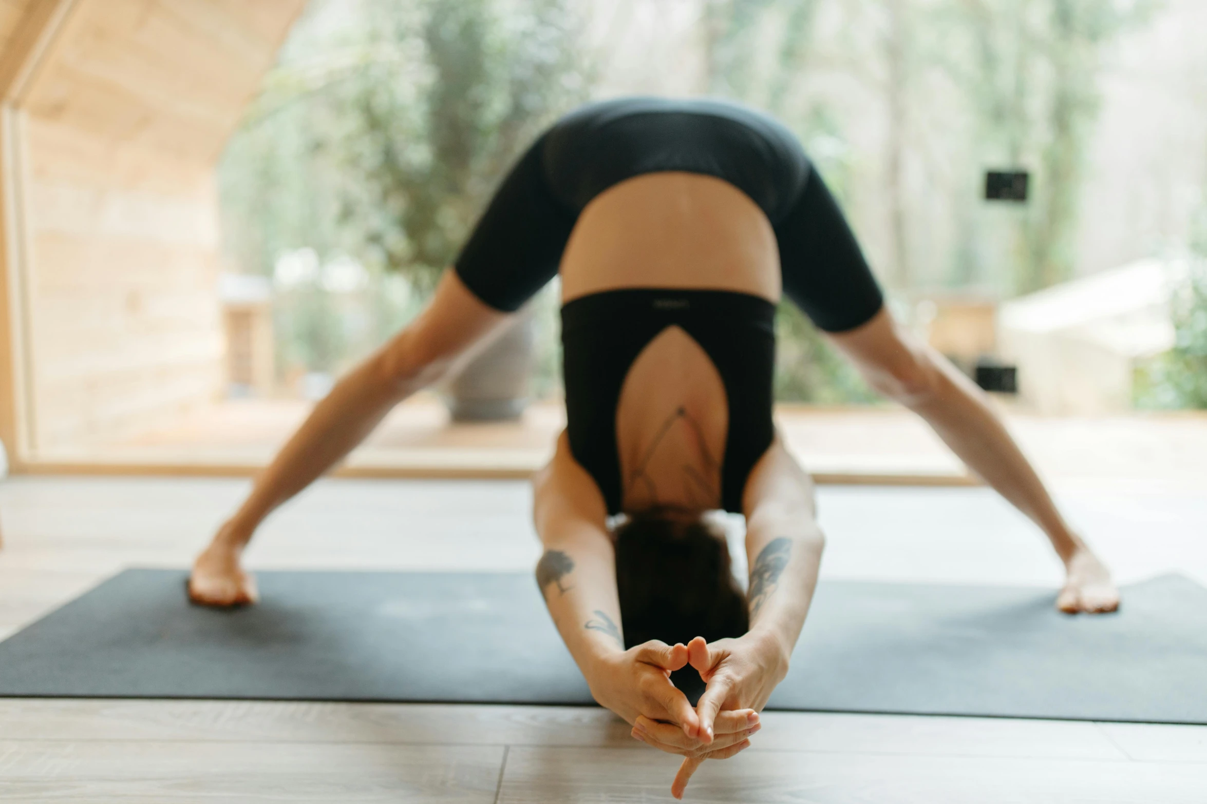 a woman doing a handstand pose on a yoga mat, a picture, unsplash, arabesque, doing splits and stretching, pointed arches, manuka, hands pressed together in bow