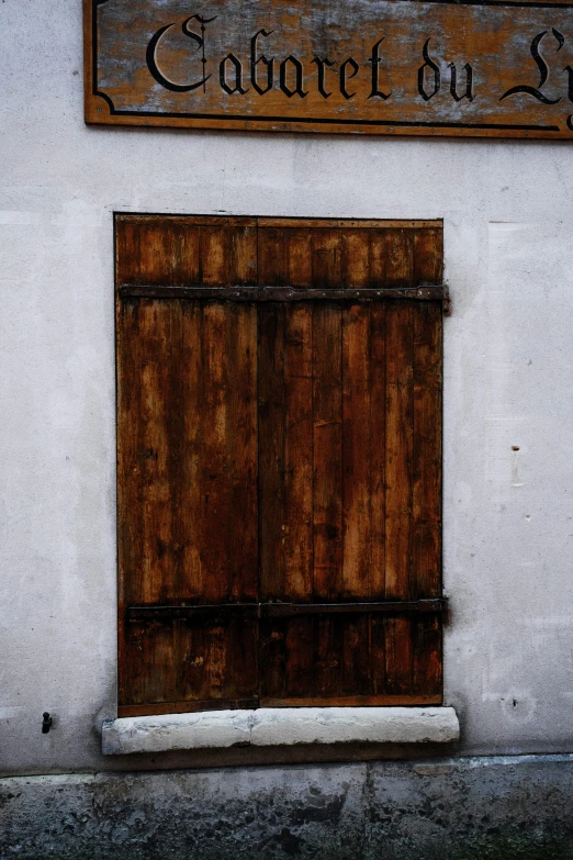 a red fire hydrant sitting in front of a building, by Andor Basch, renaissance, wood door, ((rust)), rustic wood, minimalissimo