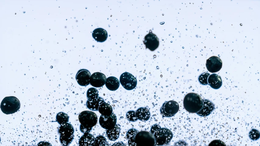 a bunch of blueberries are falling into the water, a microscopic photo, inspired by Vija Celmins, unsplash, energy spheres, 2000s photo