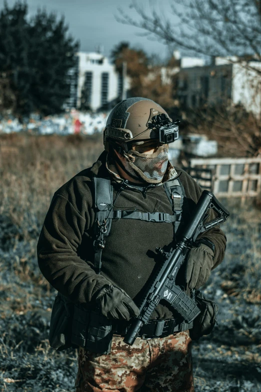 a man with a gun standing in a field, reddit, wearing tactical gear, wearing goggles, urban warfare, portrait mode photo