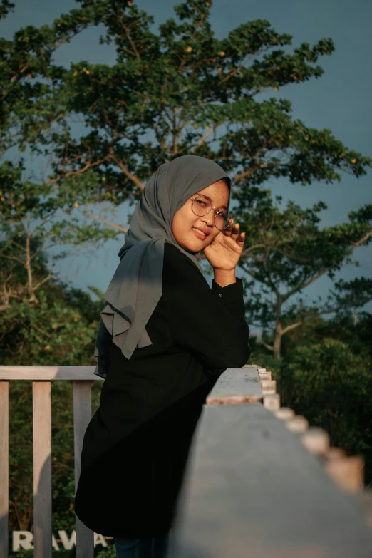 a woman in a hijab talking on a cell phone, a picture, inspired by Naza, pexels contest winner, casual pose, in the countryside, ((portrait)), at the terrace