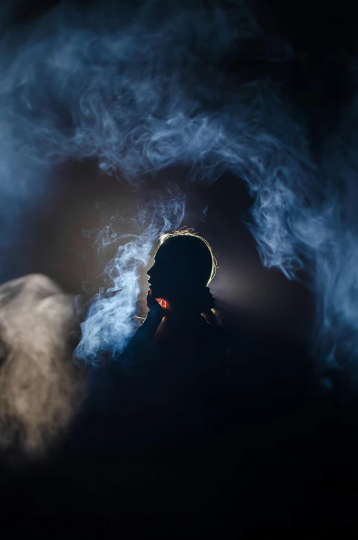 a person smoking a cigarette in the dark, a portrait, pexels contest winner, conceptual art, fractal human silhouette, smokey cannons, blue haze, shot with canon eoa 6 d mark ii