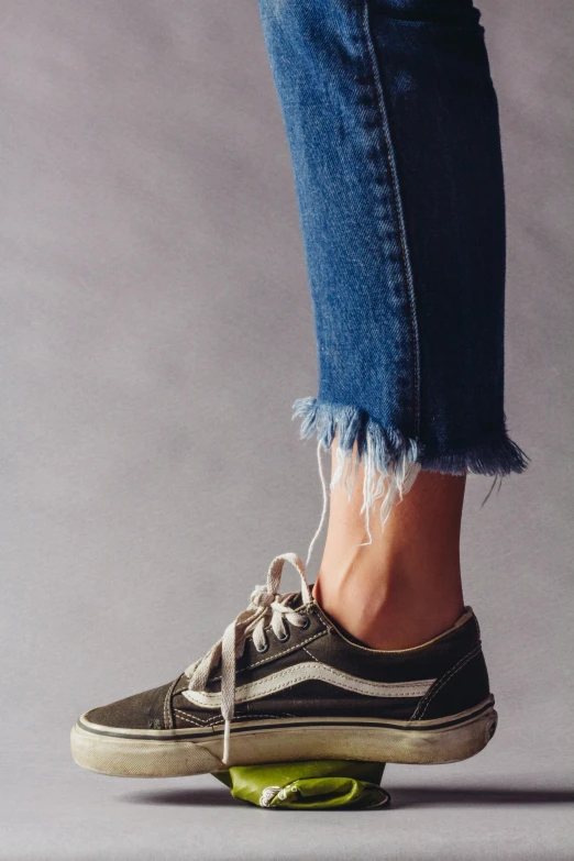 a person standing on top of a green skateboard, a colorized photo, inspired by Jean Hey, trending on pexels, blue jeans and grey sneakers, olive thigh skin, high texture detail), kailee mandel