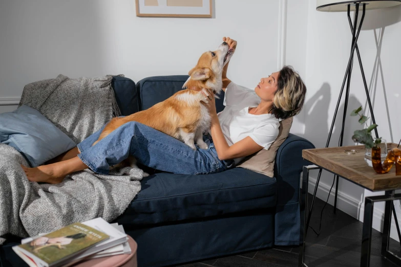 a woman laying on a couch with a dog, playing, profile image, australian, plush furnishings