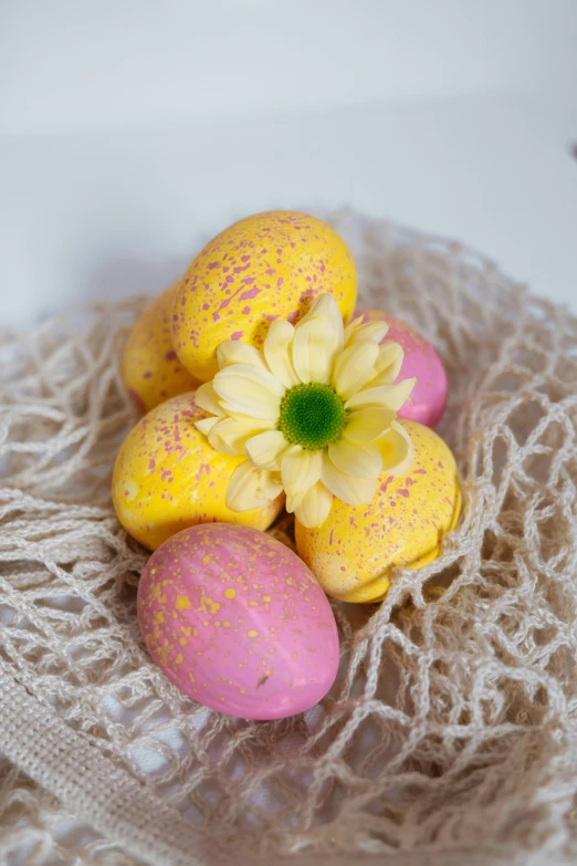 a white plate topped with yellow and pink eggs, blooming, vibrant color with gold speckles, nilah, close-up product photo