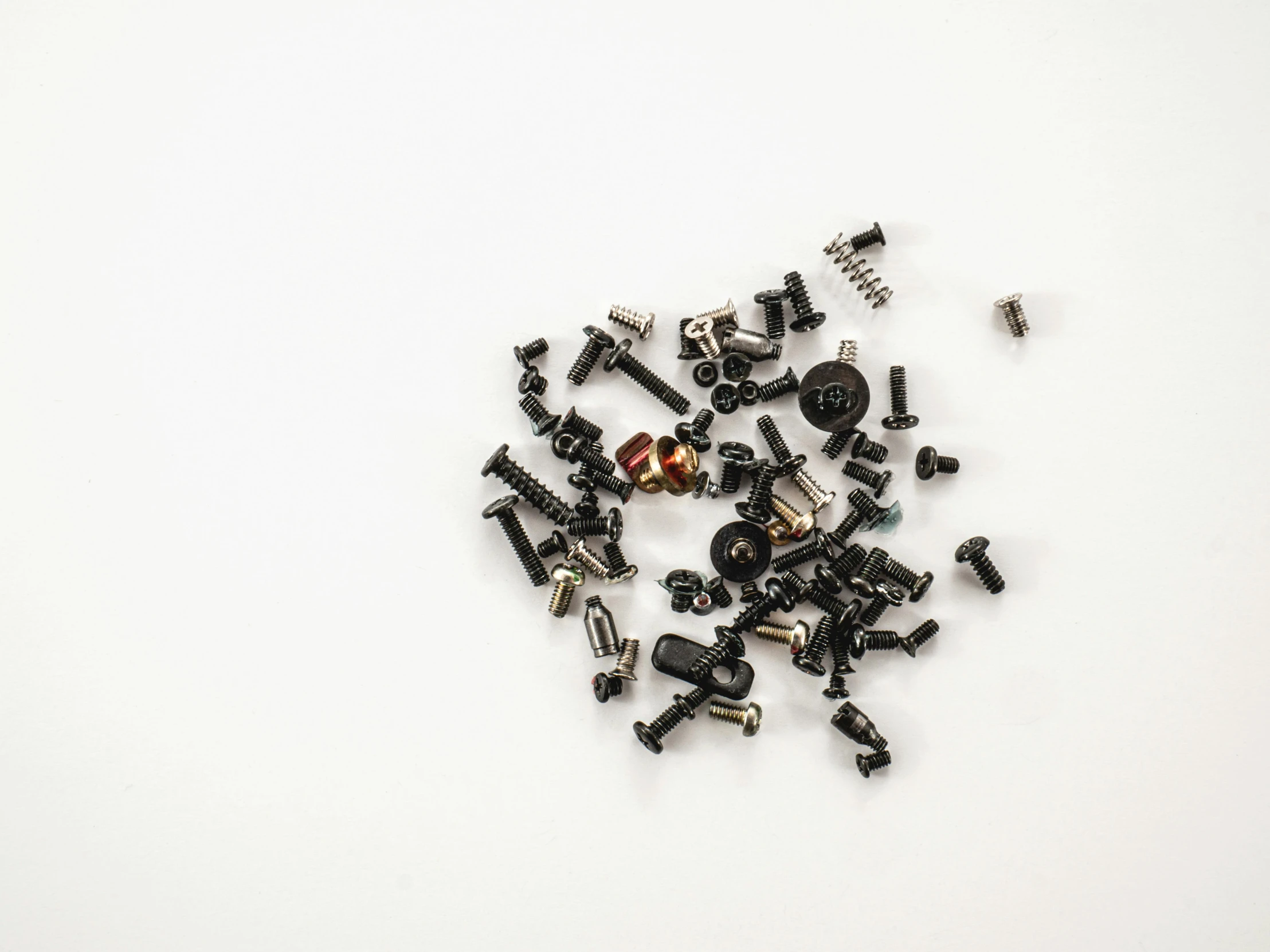 a pile of screws sitting on top of a white surface, by Adam Rex, exploded parts assembly, with black, mcu, seeds