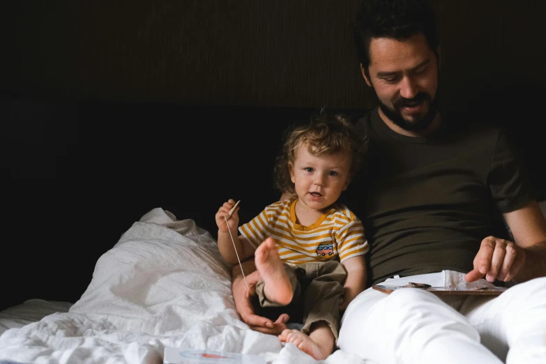 a man reading a book to a child on a bed, pexels contest winner, avatar image, pregnancy, handsome, family dinner