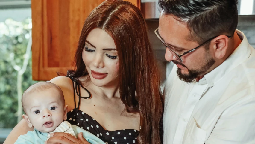 a man and woman holding a baby in a kitchen, a portrait, reddit, young beautiful amouranth, profile image, fan favorite, youtube thumbnail